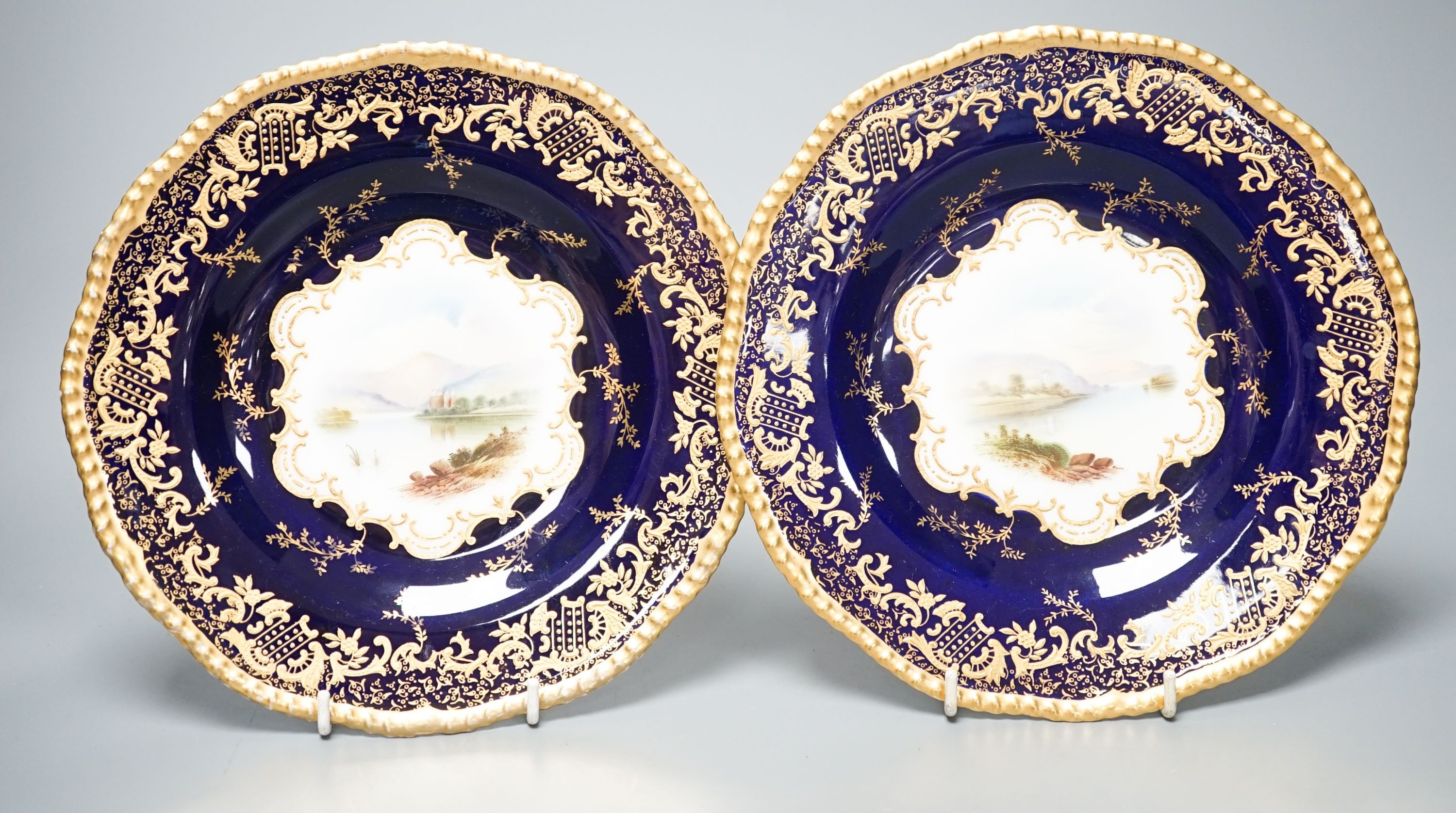 A pair of Coalport landscape plates painted by J. Oldfield with loch scenes, impressed date code for 1909, diameter 23cm